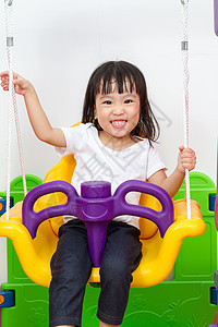 亚裔中国小女孩玩摇摆游戏快乐儿童微笑幸福闲暇操场享受喜悦女性公园图片