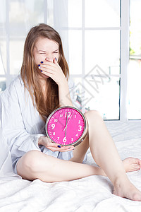 清晨在床上敲钟的年轻女青年卧室女性警报枕头唤醒女士成人说谎苏醒幸福图片