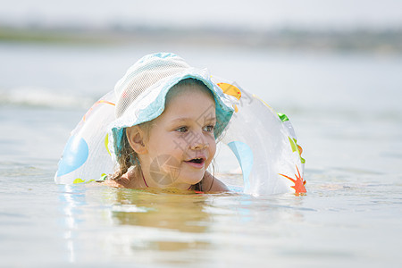 河里游泳孩子四岁女孩在河里漂浮着圆圈背景