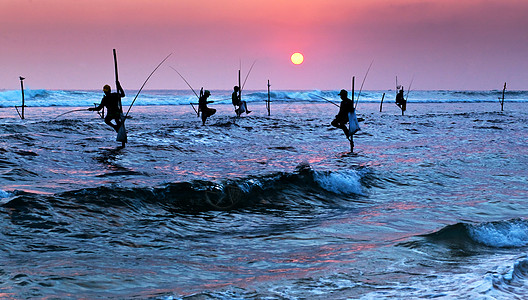 夜钓鱼日落之夜传统矮渔夫的休眠轮椅天空男性海洋男人旅行平衡太阳日落高跷食物背景
