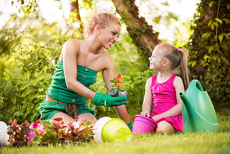 美丽的母亲和女儿种花鲜花盆栽设备小姑娘花园孩子们享受幸福植物学园艺植物图片