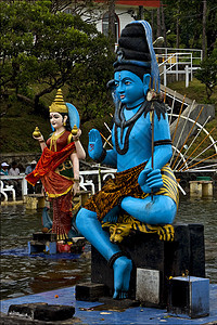 非洲马留修斯山的印度教蛇雕像寺庙艺术木头套装卷曲祷告弯曲蓝色裙子上帝图片
