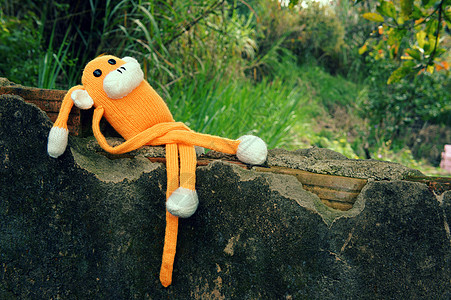 201 年的针织孤独猴子象征玩具寂寞手工说谎橙子猴年印象悲伤紫色羊毛背景图片