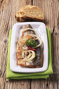 泛炸鳟鱼食物吃饭餐巾盘子主菜白色洋葱红辣椒油炸午餐图片