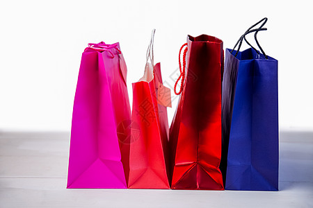 桌上礼品袋红色木头粉色零售购物礼物标签展示蓝色背景图片