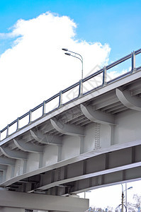 蓝色天空下有云的蓝天背景上的汽车飞越立交桥柱子工程运输地标海岸线人行道建筑学天际驾驶图片