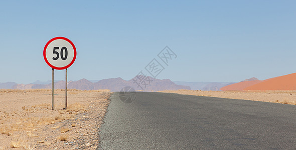 纳米比亚一条沙漠公路上限速标志手表柏油沥青速度衬套圆形警告极限丘陵平原图片