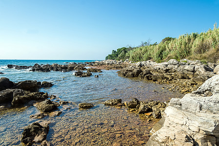 亚得里亚海滨阳光明媚的一天海岸线地平线阳光石头岩石场景太阳蓝色假期气候图片