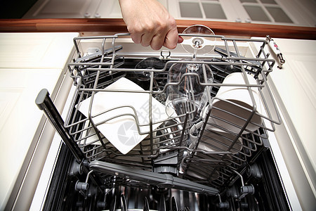 女人用干净的工具打开洗碗器的手图片