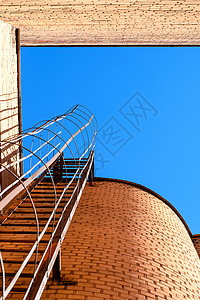 建筑物的工业梯子 蓝色天空和砖墙金属进步建筑建造危险晴天安全天堂房子青色图片