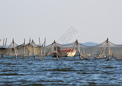 离近海渔网和捕捞网附近的小船图片