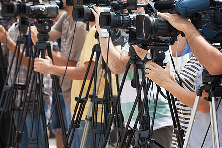 记者招待会 用摄像头拍摄一个事件电视发布会媒体摄影师播送操作员新闻报告镜片麦克风背景图片