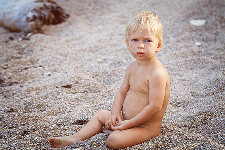 小男孩在沙滩上喜悦阳光人类摄影乐趣婴儿椅子日光浴快乐头发图片