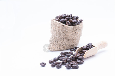 咖啡豆在木制勺子里 和从一个赫西亚的b溢出豆子白色咖啡黄麻饮料麻布食物解雇棕色图片