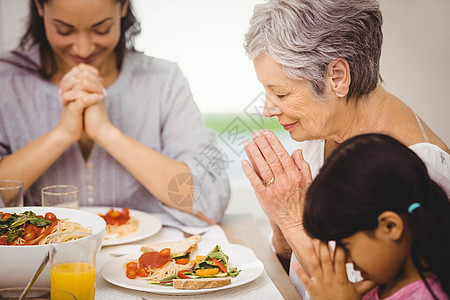 家人在吃饭前一起祈祷家庭生活双手混血果汁亲密感女性食物闲暇房子住所图片