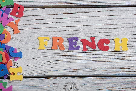在白木板上用彩色字母 写着多彩的法语字乡村脚本社会木头积木标签拼写字体英语凸版图片