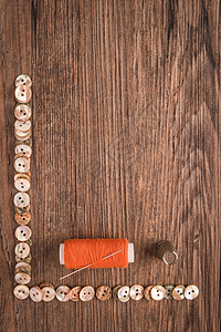 缝针缝合针和橙色线 准备缝纫 按钮框纽扣夹子卷轴刀刃工具手工木头爱好筒管工作图片