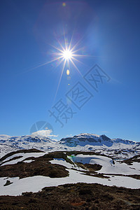 春季山谷地貌蓝色顶峰爬坡苔藓岩石风景天空白色太阳背景图片