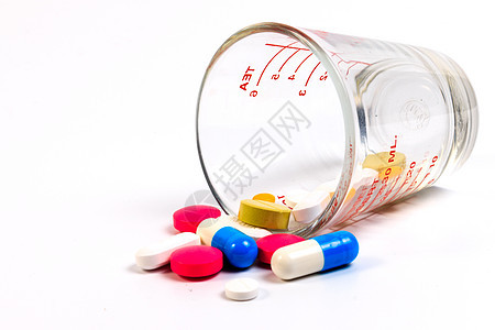白色背景的玻璃杯里 有许许多多彩色的药丸尺寸配饰桌子玻璃药片药店测量补给品注射器医疗图片