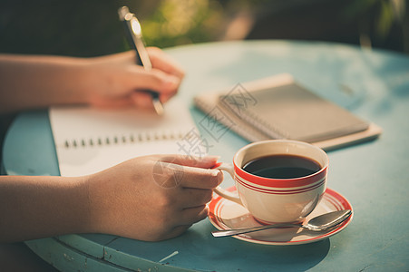 清晨室外咖啡休息时间会议闲暇宽慰记录笔记本桌子杯子享受咖啡店杂志图片