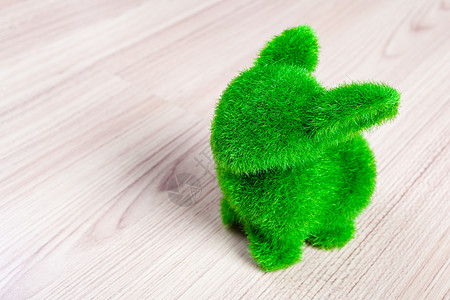 甜咪兔木地板上的小绿兔 用人造草制成耳朵哺乳动物草地场地眼睛花园兔子野生动物毛皮动物背景