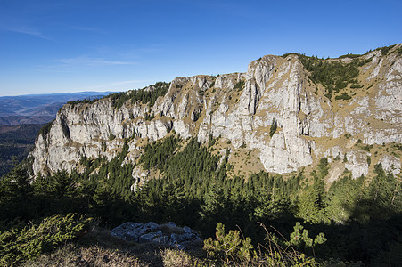 山上岩墙蓝色森林旅游季节远足小路顶峰远足者冒险登山图片