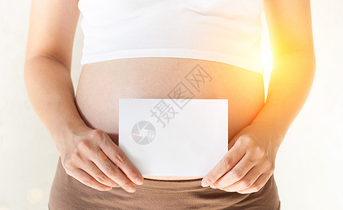 孕妇将手握在肚子上 并举着一刀女士腹部生育女性女孩母性男生孩子阳光小样图片