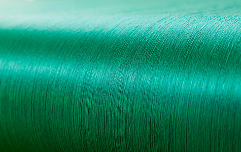 一家纺织厂织物机的折叠圈上的绿丝绸织物编织棉线别针工厂细绳团体纺织品纤维布料图片