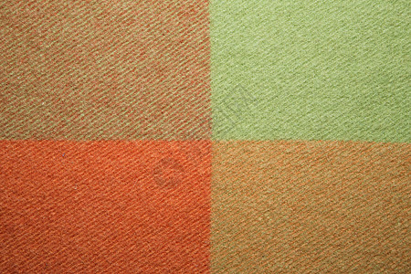柔软温暖的折叠羊驼毛毯 绿色和橙色羊毛格子纹理微距拍摄 羊毛格子质地羊毛毯背景图片