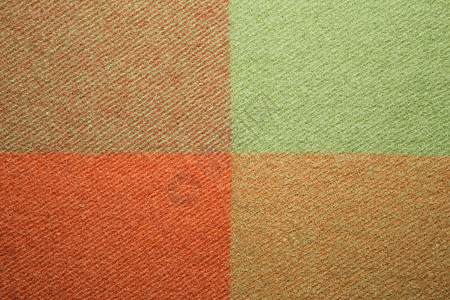 柔软温暖的折叠羊驼毛毯 绿色和橙色羊毛格子纹理微距拍摄 羊毛格子质地羊毛毯背景图片