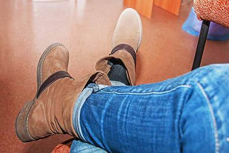 穿着棕靴子 女鞋 坐在沙发上女士丝袜男人魅力鞋类皮革女性绑腿性别工作室图片