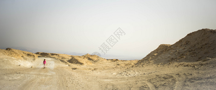 在犹太人节那天家庭在沙漠中徒步旅行旅游石头远足游客假期死海背景
