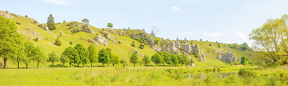 全景  绿色草地悬崖骨科旅行天空岩石丘陵蓝色水草甸牧场图片