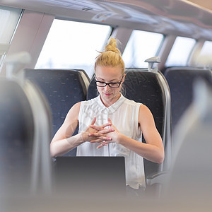 妇女在火车上行驶时窒息商业工作乘客笔记本公共汽车拉伸女士互联网女性商务图片
