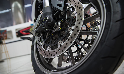 摩托车上新的闪亮制动盘技术金属速度运动发动机自行车维修工程力量圆圈图片