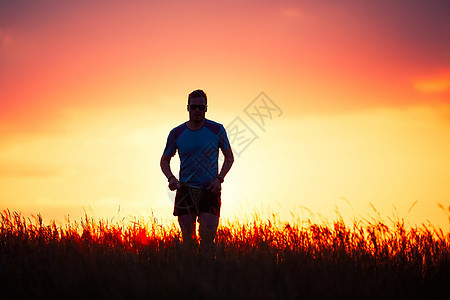 日落时的运动运动员赛跑者状况训练自由慢跑晴天热情太阳草地男人图片