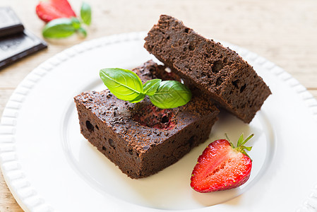 白盘上的巧克力布朗尼蛋糕 上面装饰着草莓小吃美食正方形糕点烹饪食物盘子餐厅可可面包图片