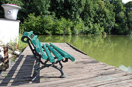 看着湖和森林的木板凳叶子阳光农村风景公园太阳旅行环境长椅草地图片