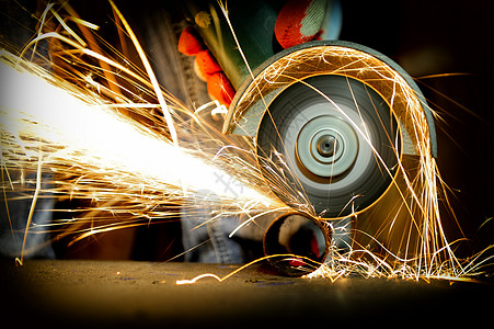 工人用研磨机切割金属研磨火花工具生产钻石车轮机器钻头旋转圆圈图片