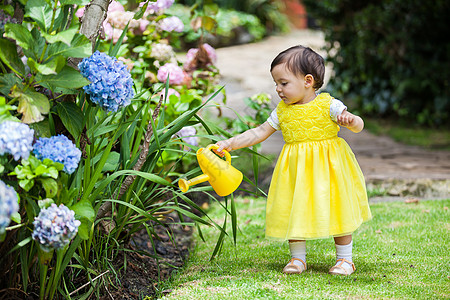 小婴儿给植物浇水女孩喷涂喷壶花园裙子黄色小姑娘花朵图片