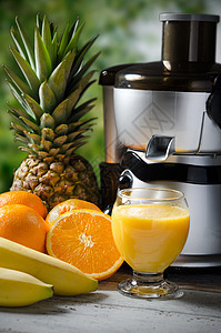 鲜果汁和果汁机 木制背景照片用具香蕉搅拌机玻璃橙子营养食物房子机器饮料图片