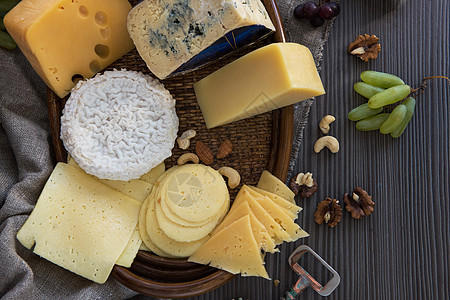 各种种类的奶酪包小吃团体农场石板桌子乡村拼盘蓝色美食杏仁背景