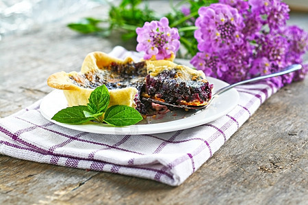 盘子和紫花上的蓝莓塔板餐巾水果叶子蛋糕浆果奶油陶器甜点紫色毛巾图片
