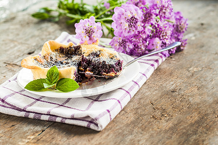 盘子和紫花上的蓝莓塔板餐巾叶子馅饼紫色桌子摄影奶油乡村浆果糕点图片