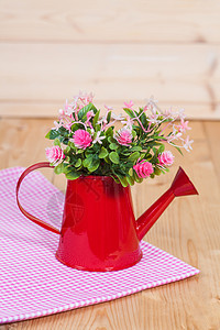 用红花浇在木柴上花瓶装饰粉色花束绿色房子桌子风格白色叶子图片