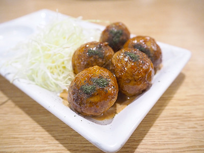 白盘子上的日本菜塔可雅木油炸美食小吃乌贼海鲜食物棕色圆圈盘子烹饪图片