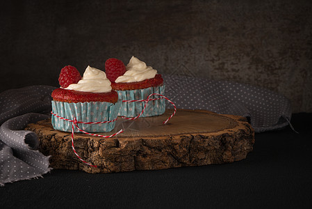 带有奶油奶酪霜冻的红纸杯蛋糕漩涡奶油牛奶糕点面包香草派对木头甜点冰镇图片