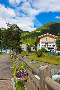 意大利阿尔卑斯山村街旅行天空溪流行人别墅高山村庄旅游花朵树木图片