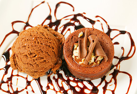 带冰淇淋的蜜巧克力栗子蛋糕配料甜点糖浆圆形榛子盘子卷发蛋糕食物奶油背景