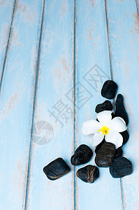 木地板上黑石组上的花石头花园假期碎石海滩温泉装饰品棕色黑色木头背景图片